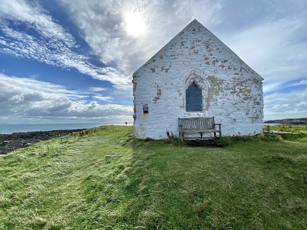 white wooden house on green grass field under blue sky during daytime