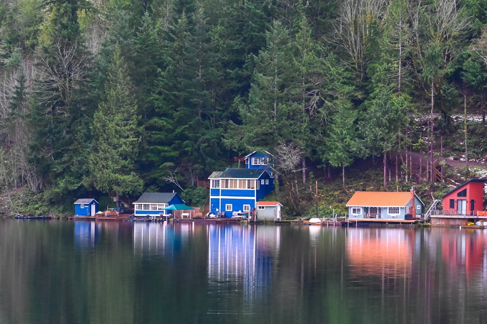 blue and red house beside lake during daytime