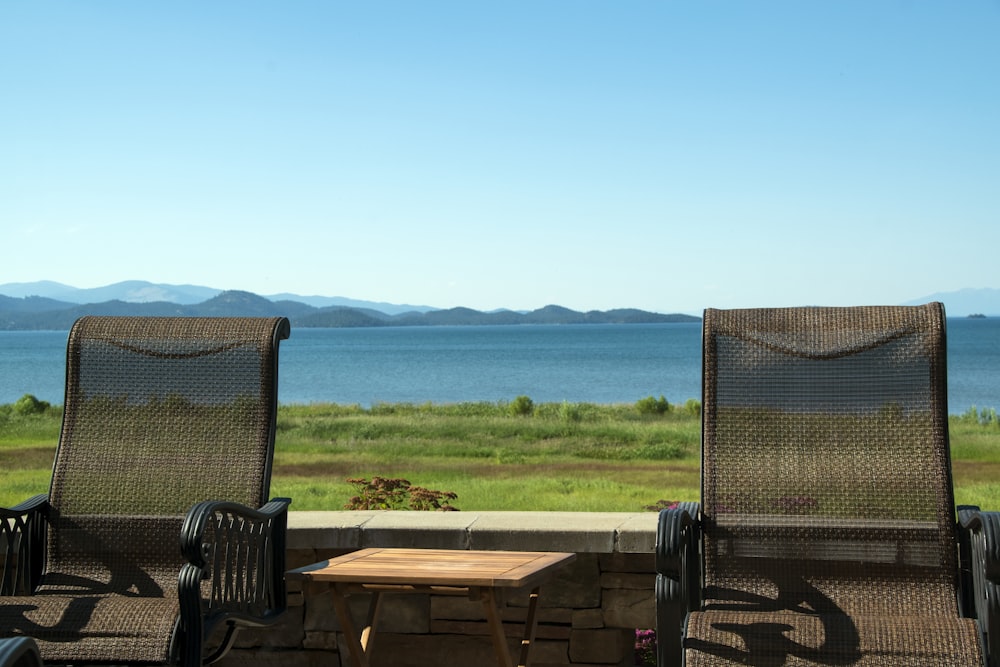 brown wooden table and chairs near sea during daytime