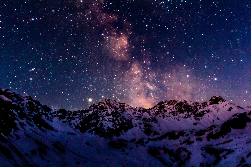 Montagna coperta di neve sotto la notte stellata