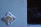 A close-up view of a metallic door lock set in a painted surface, with visible scratches and wear on the paint. To the right, there is a dark glass pane.