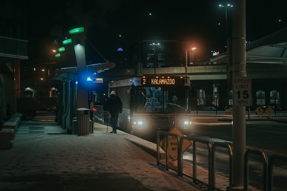 man in black jacket standing near store during night time