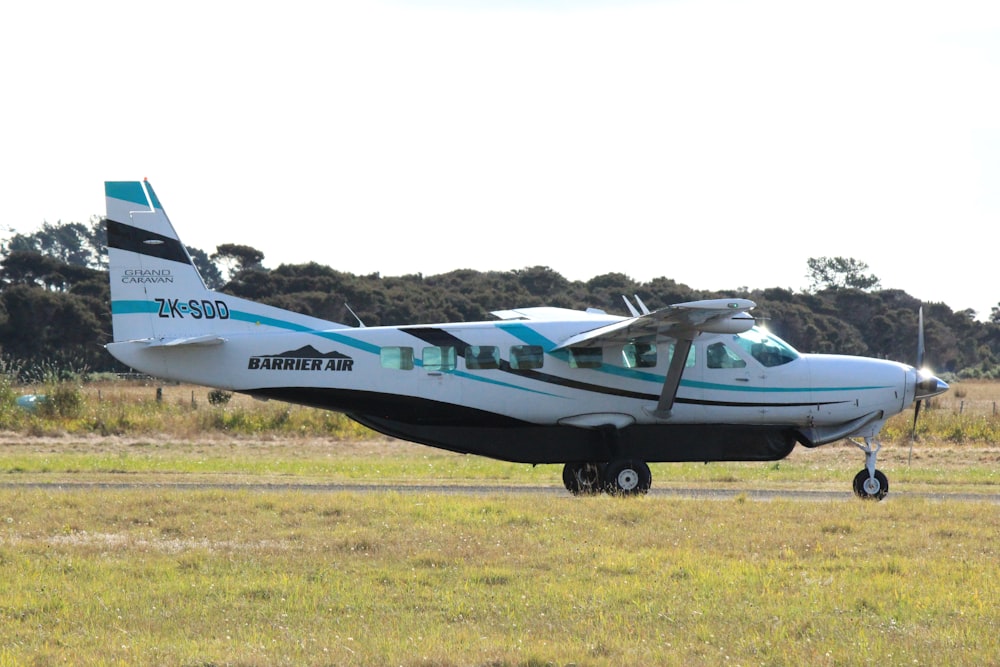 blue and white jet plane on green grass field during daytime