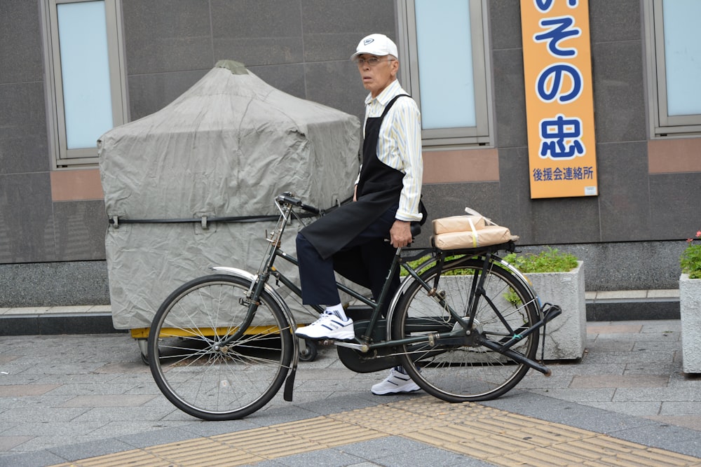 man in white dress shirt and black pants riding on black bicycle