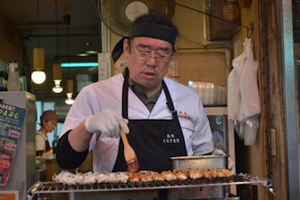 man in white chef uniform holding knife slicing meat