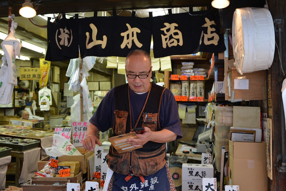 man in green crew neck t-shirt holding brown book