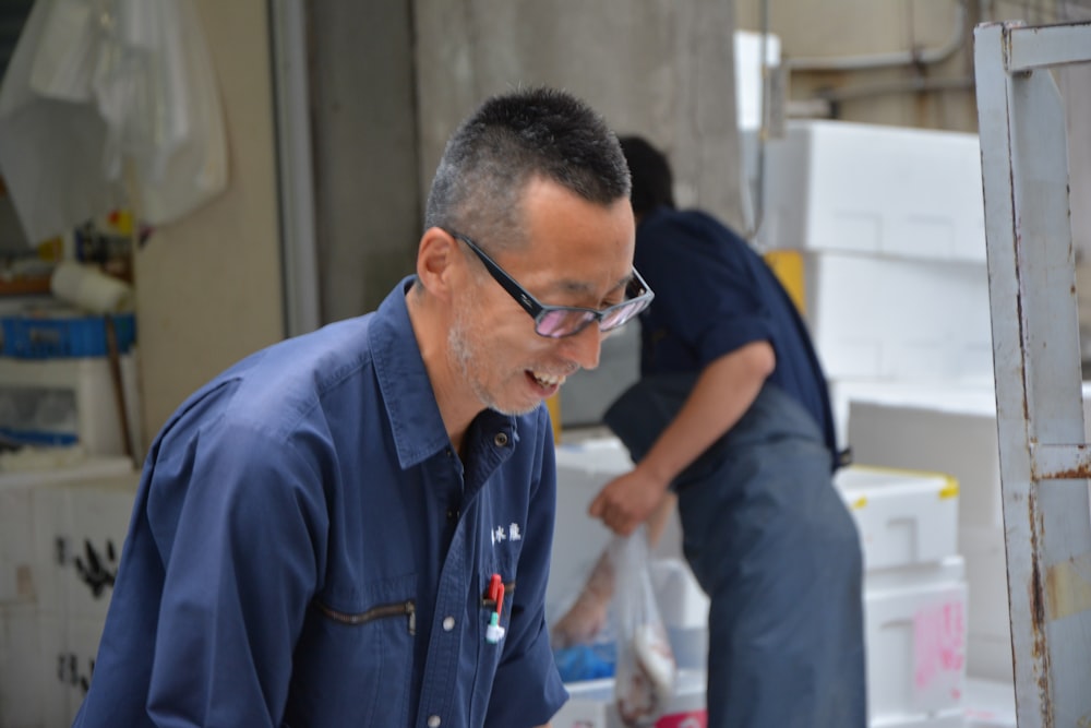 man in blue button up shirt wearing black framed eyeglasses