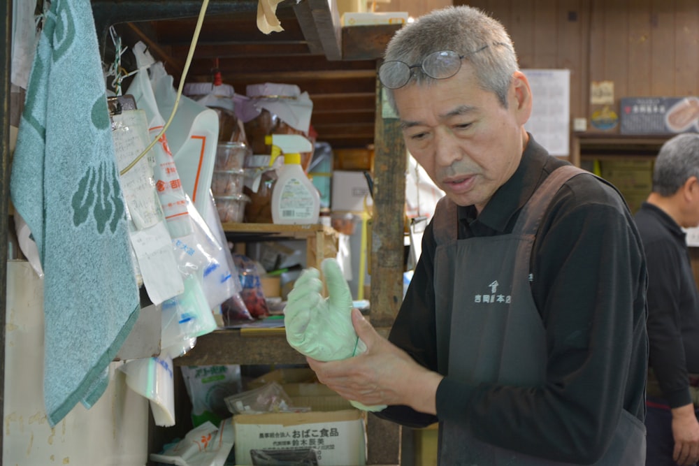 man in black polo shirt holding green plastic pack