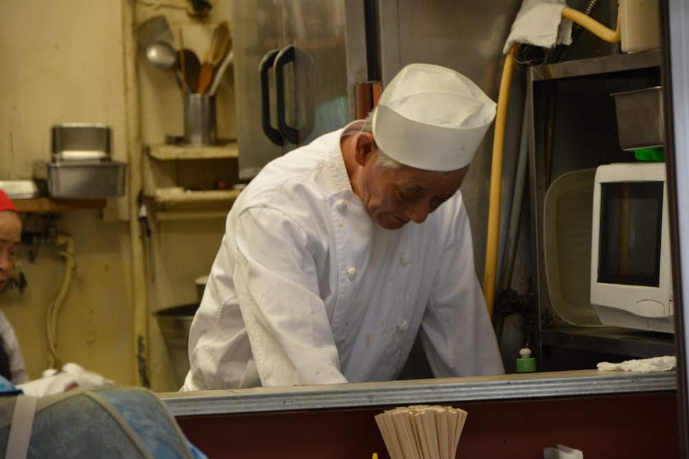 man in white chef uniform sitting on train seat