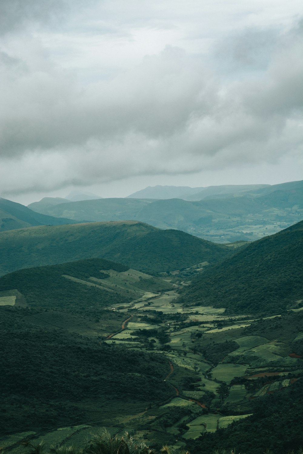 a view of a valley and mountains from the top of a hill