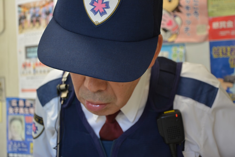 man in blue and white uniform wearing black cap