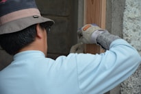 man in white long sleeve shirt and black cap holding gray and white cat