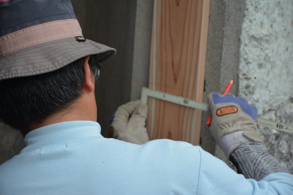 man in white shirt and black hat holding gray and red toy gun