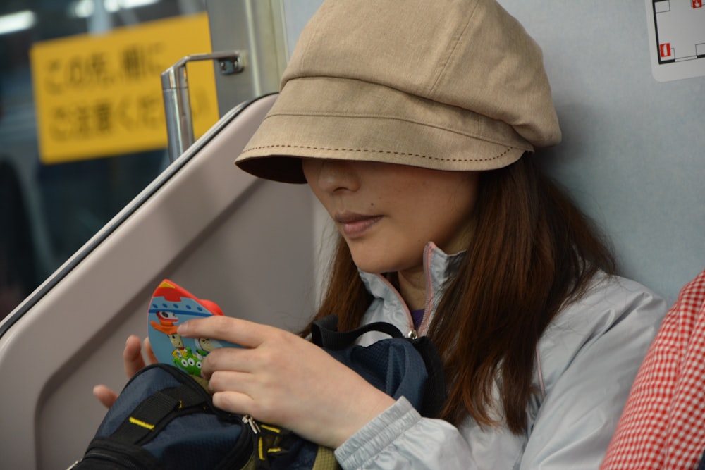 woman in white jacket wearing brown cap