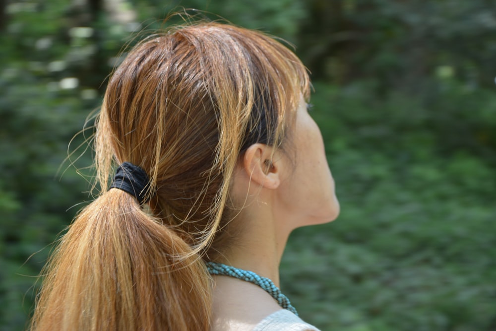 woman in white and blue floral shirt with black headphones