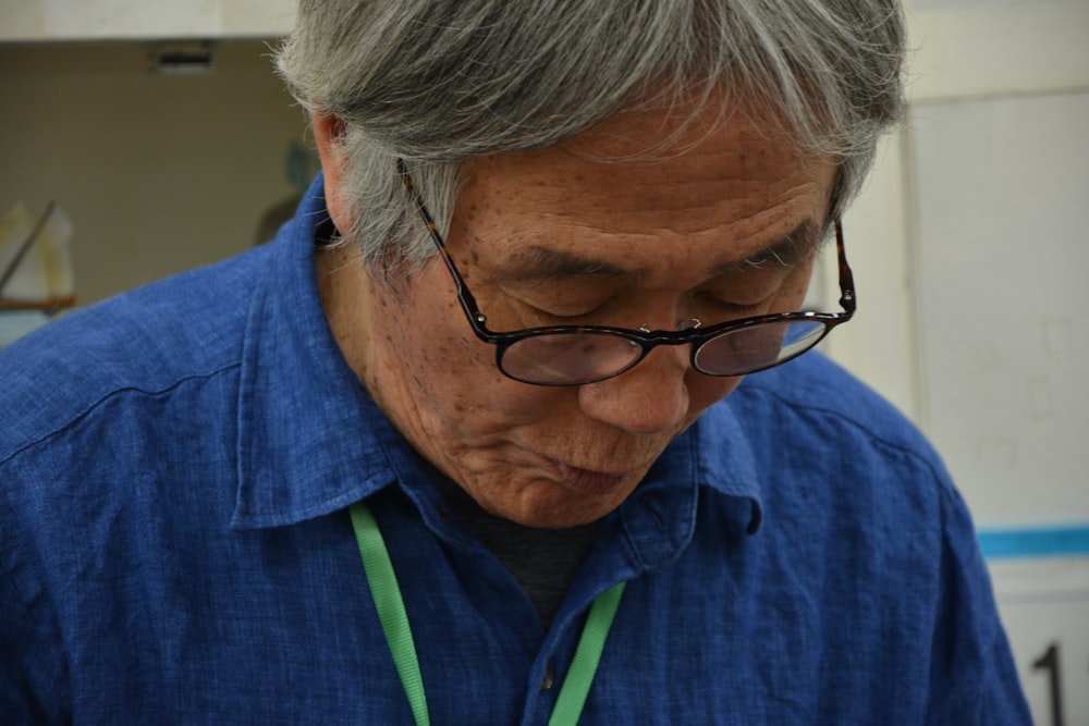 man in blue shirt wearing black framed eyeglasses