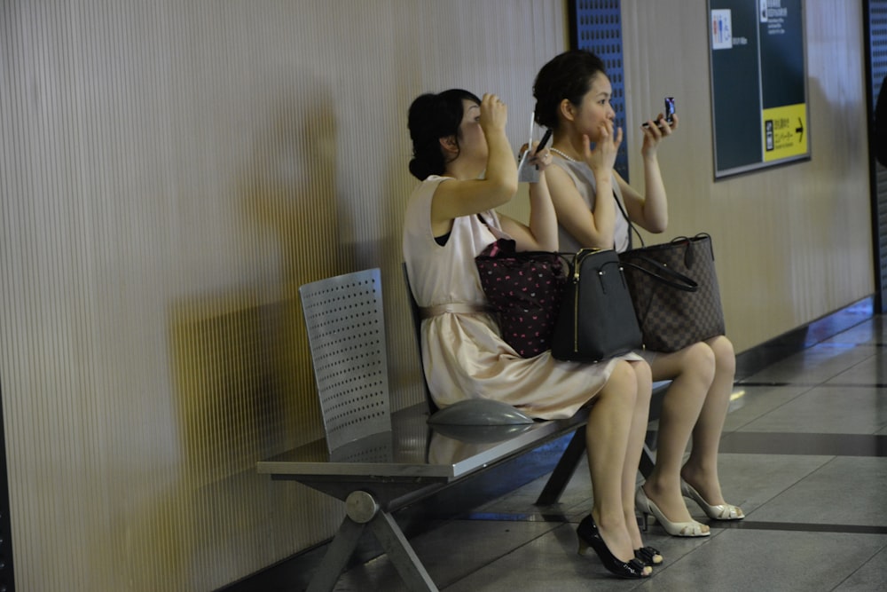 2 women sitting on chair