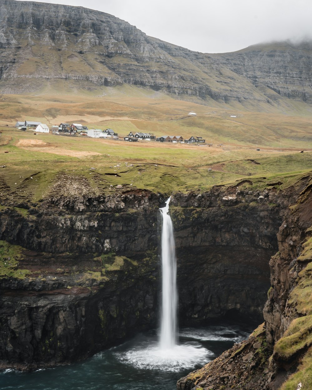 waterfalls on brown rocky mountain during daytime