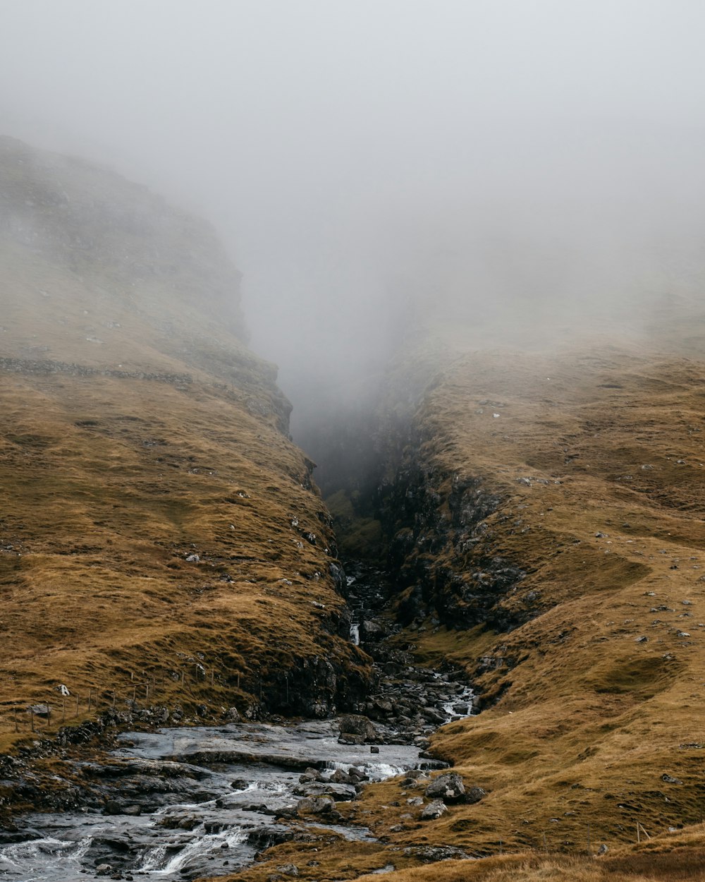 green and brown mountain beside body of water