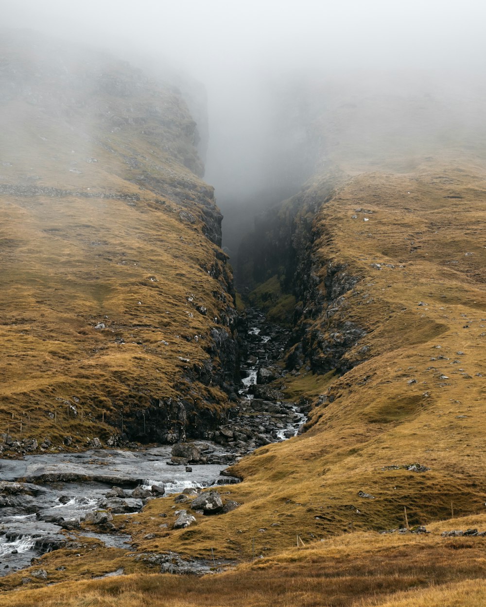 green and brown mountain beside river during daytime