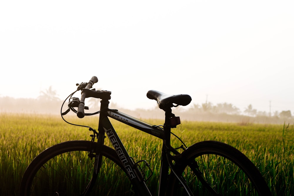 bicicletta nera sul campo di erba verde durante il giorno