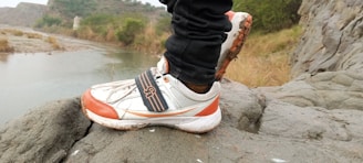 Close-up of trail running shoes on a rocky path.