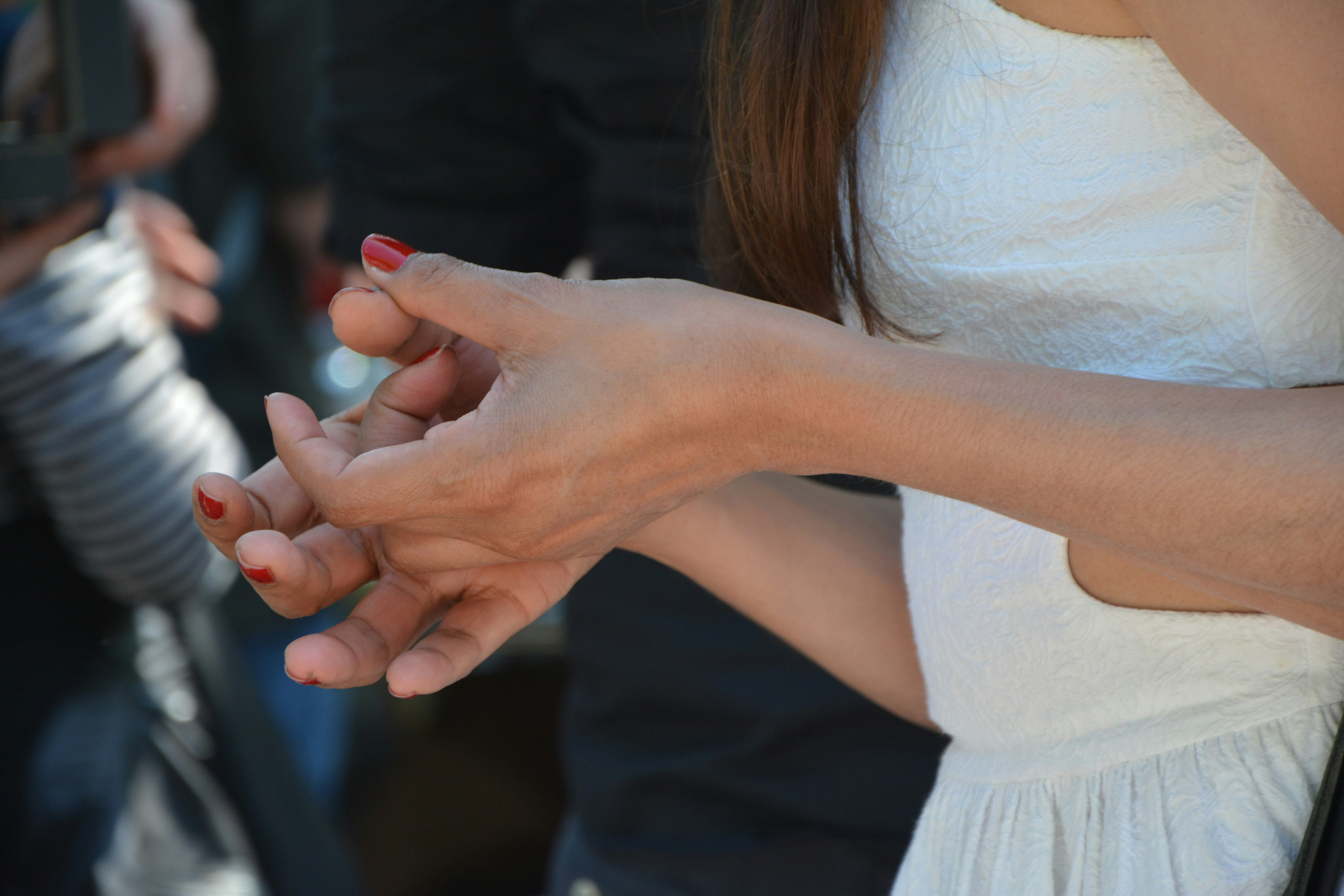 woman in white tank top holding mans hand