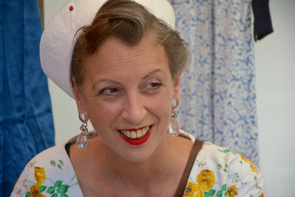 woman in white and yellow floral shirt smiling