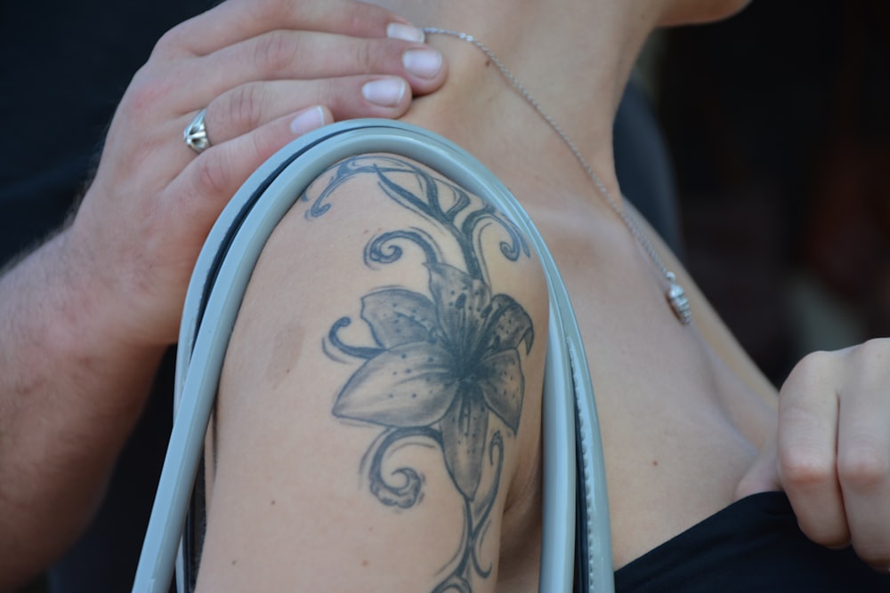 woman with black and white floral tattoo on her right shoulder