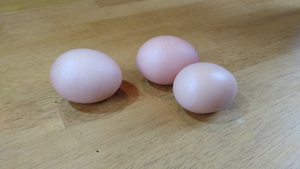 2 white eggs on brown wooden table