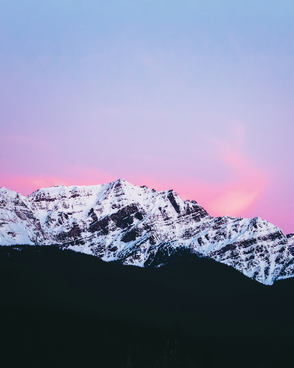 snow covered mountain under gray sky