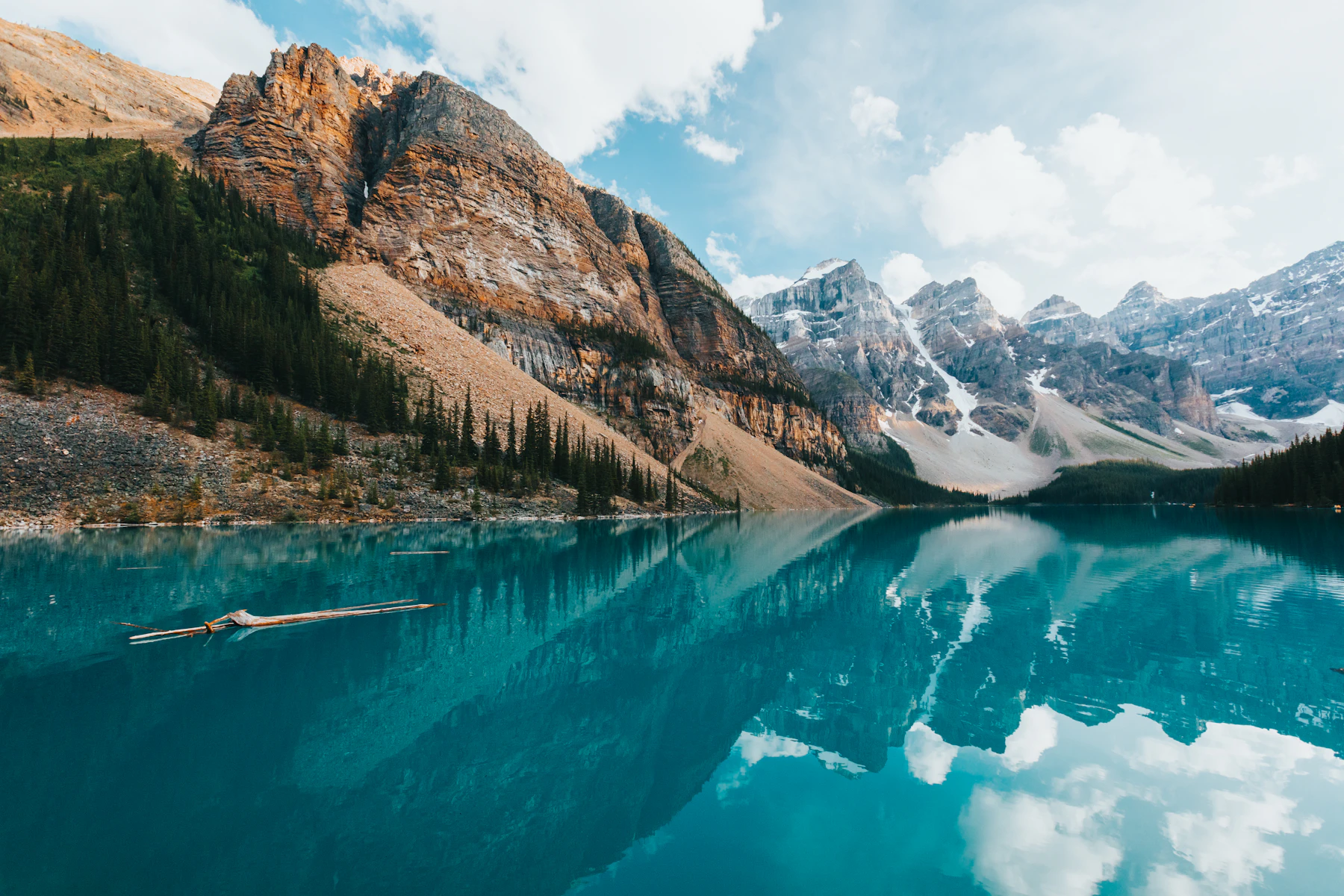 Brown and green mountains stand beside a lake.