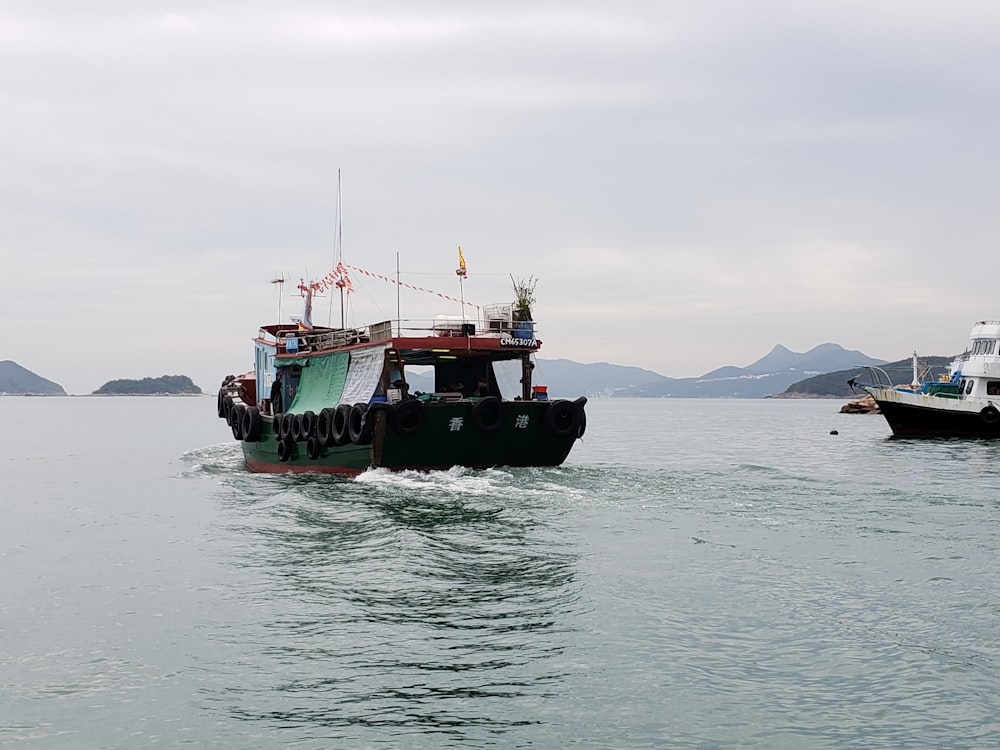 green and black boat on sea during daytime