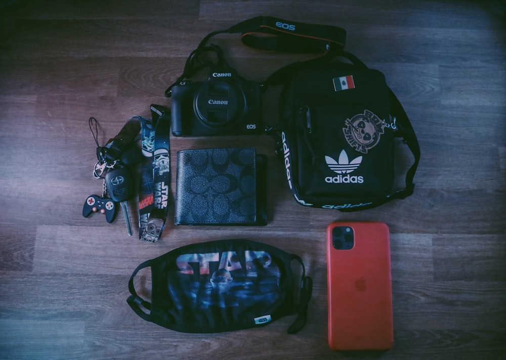 black and blue backpack beside red iphone case