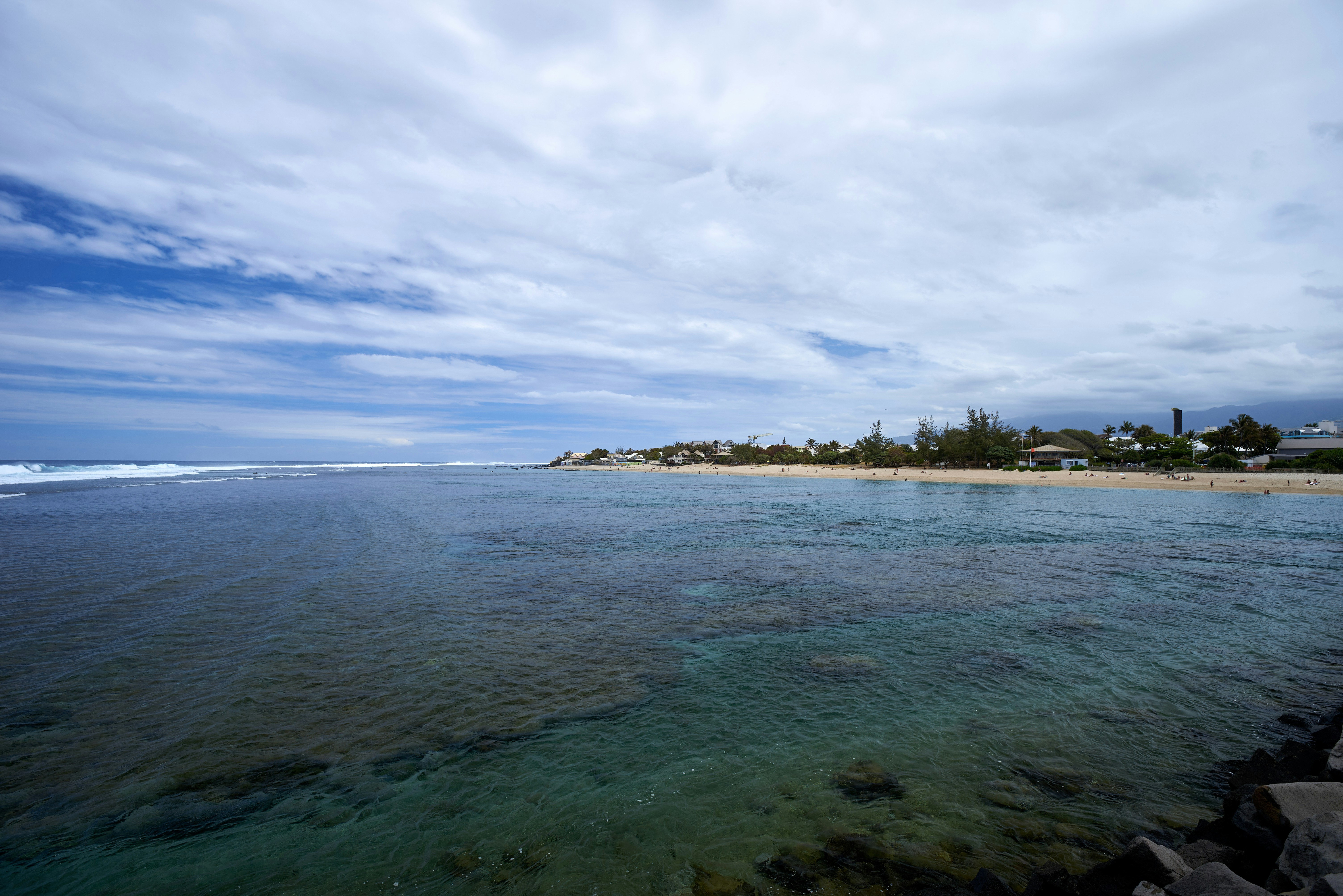 green trees on island under white clouds and blue sky during daytime
