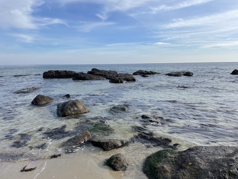 Formación rocosa marrón en el mar bajo el cielo azul durante el día
