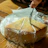 Close-up of a vacuum-packed costeño cheese on a rustic wooden table.