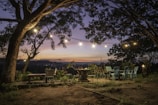 Cozy restaurant terrace overlooking trees and hills during golden hour.
