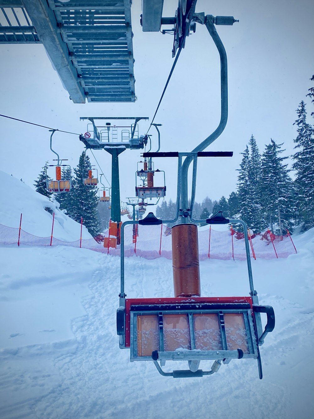 teleférico vermelho e preto sobre o chão coberto de neve