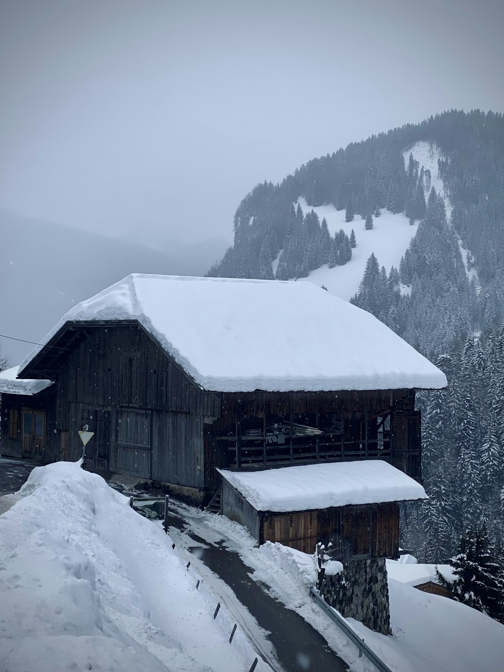 昼間の雪に覆われた地面に茶色の木造住宅