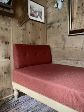 Bright bedroom showcasing a vibrant red area rug under a wooden bed frame.