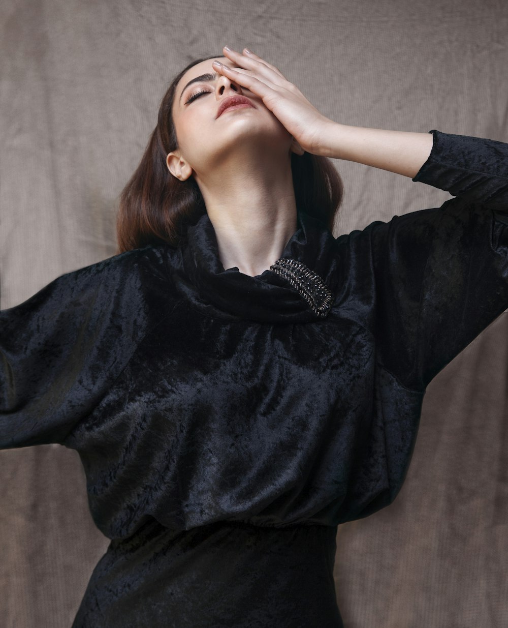 woman in black long sleeve shirt covering her face