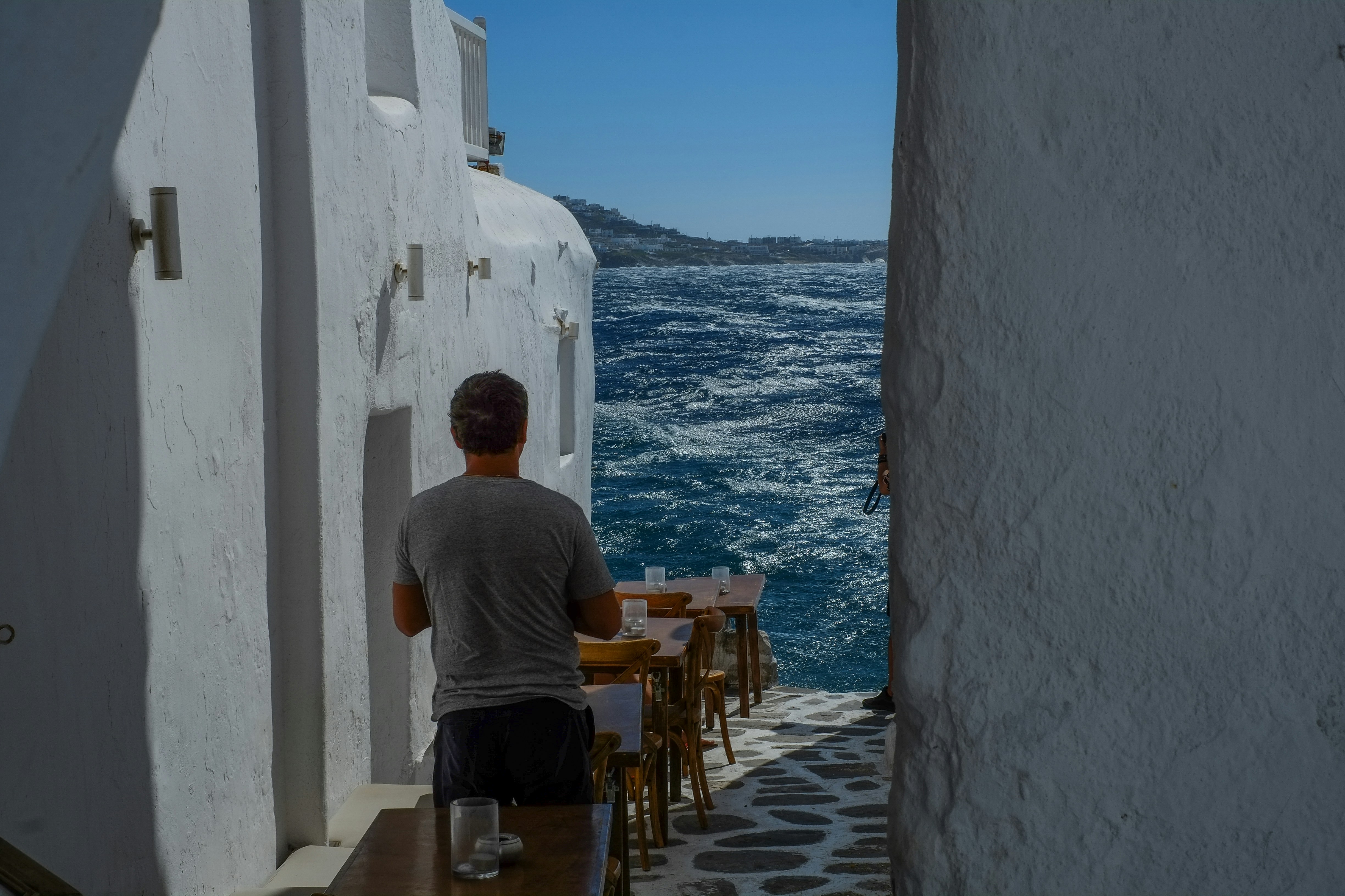 man in gray crew neck t-shirt sitting on brown wooden chair during daytime (Photo by Patrick McGregor on Unsplash)