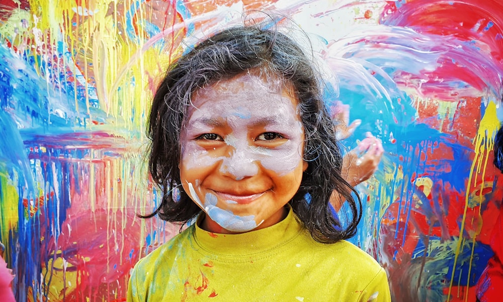 girl in yellow crew neck shirt with white powder on face