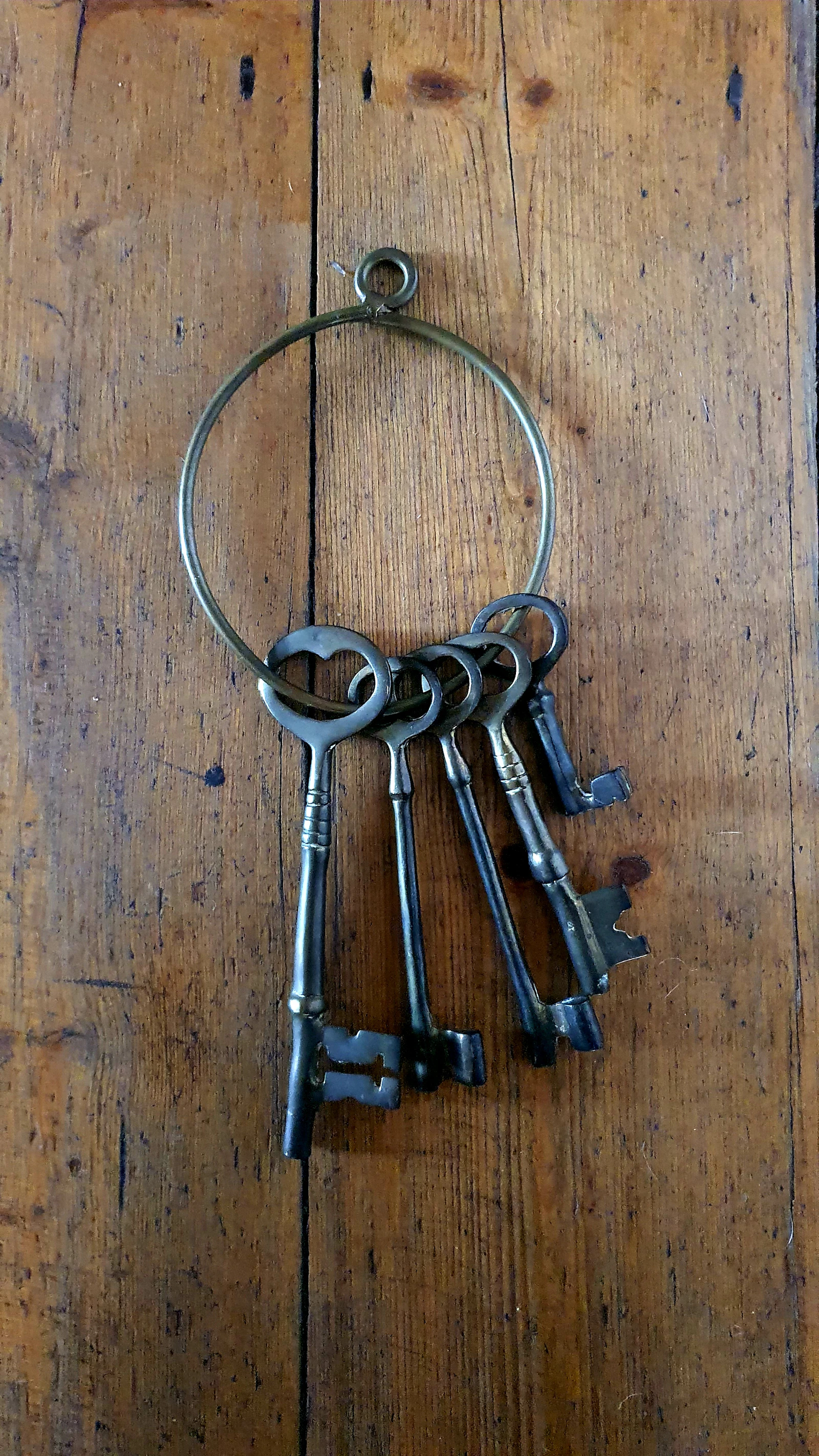 Silver skeleton keys resting on a brown wooden table