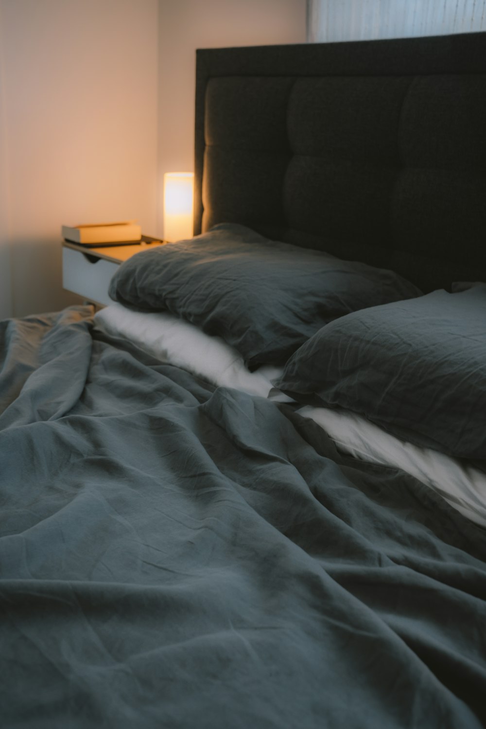 black bed linen near brown wooden nightstand