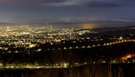 Night view of the illuminated cityscape of Lima with mountains in the background.