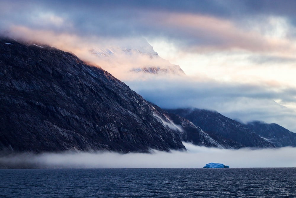 white boat on sea near mountain during daytime