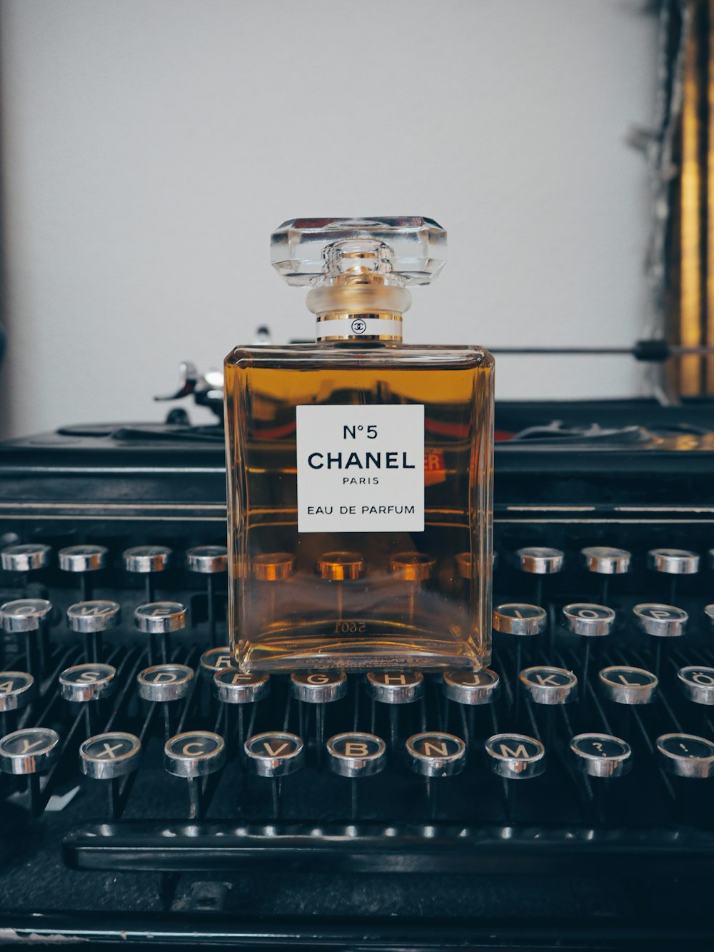 a bottle of perfume sitting on top of a typewriter