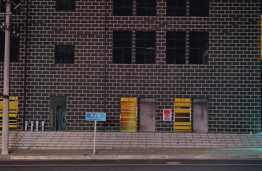 brown brick building with white and yellow road sign